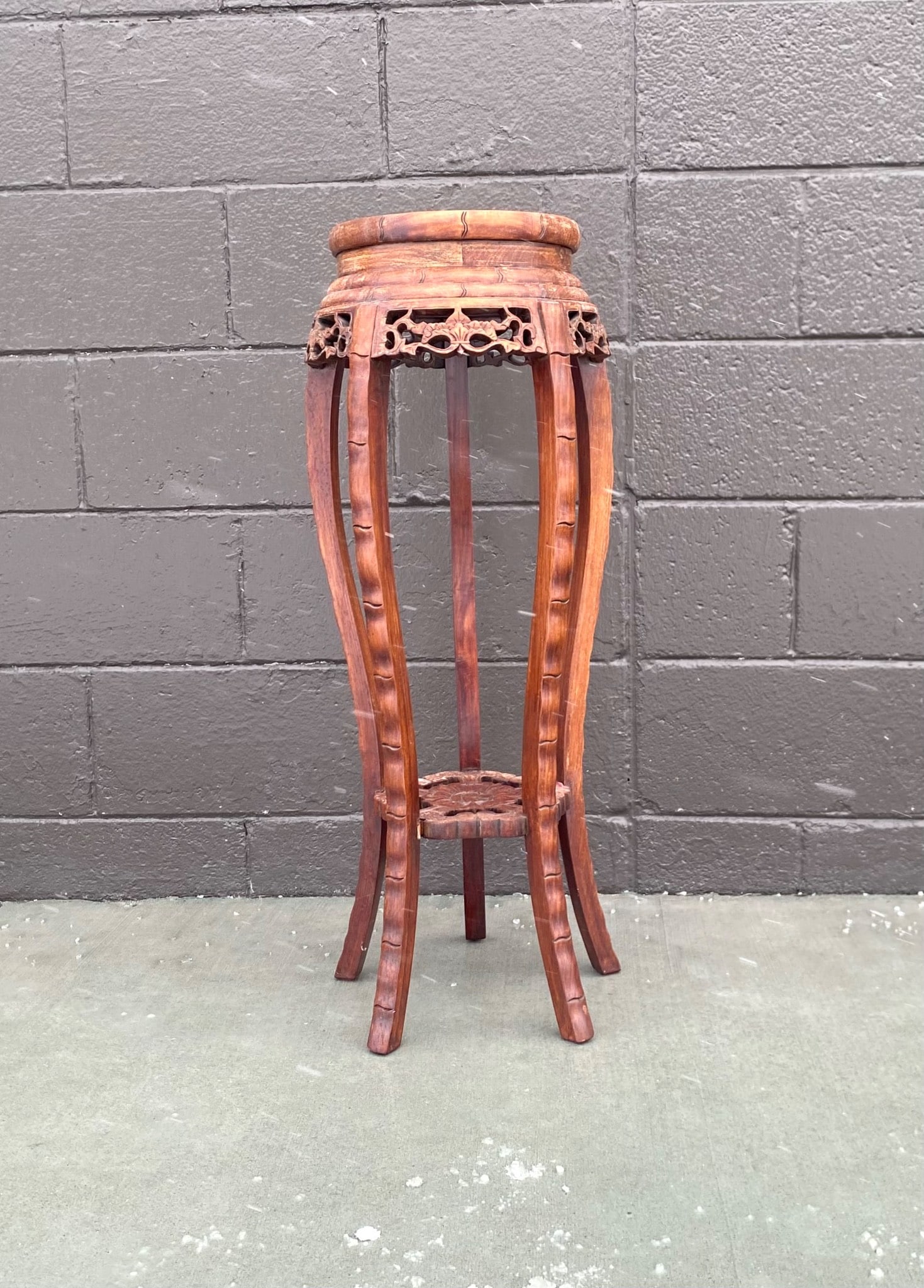 Carved Wooden Plant Stand with Marble Top: Carved wooden plant stand featuring intricate floral and openwork detailing. The stand is crafted from wood with a rich finish. It features a marble top and curved legs. | Dimensions: 32.25 inches by