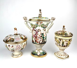 Three Capodimonte Porcelain Lidded Urns with Cherub and Floral Motifs
