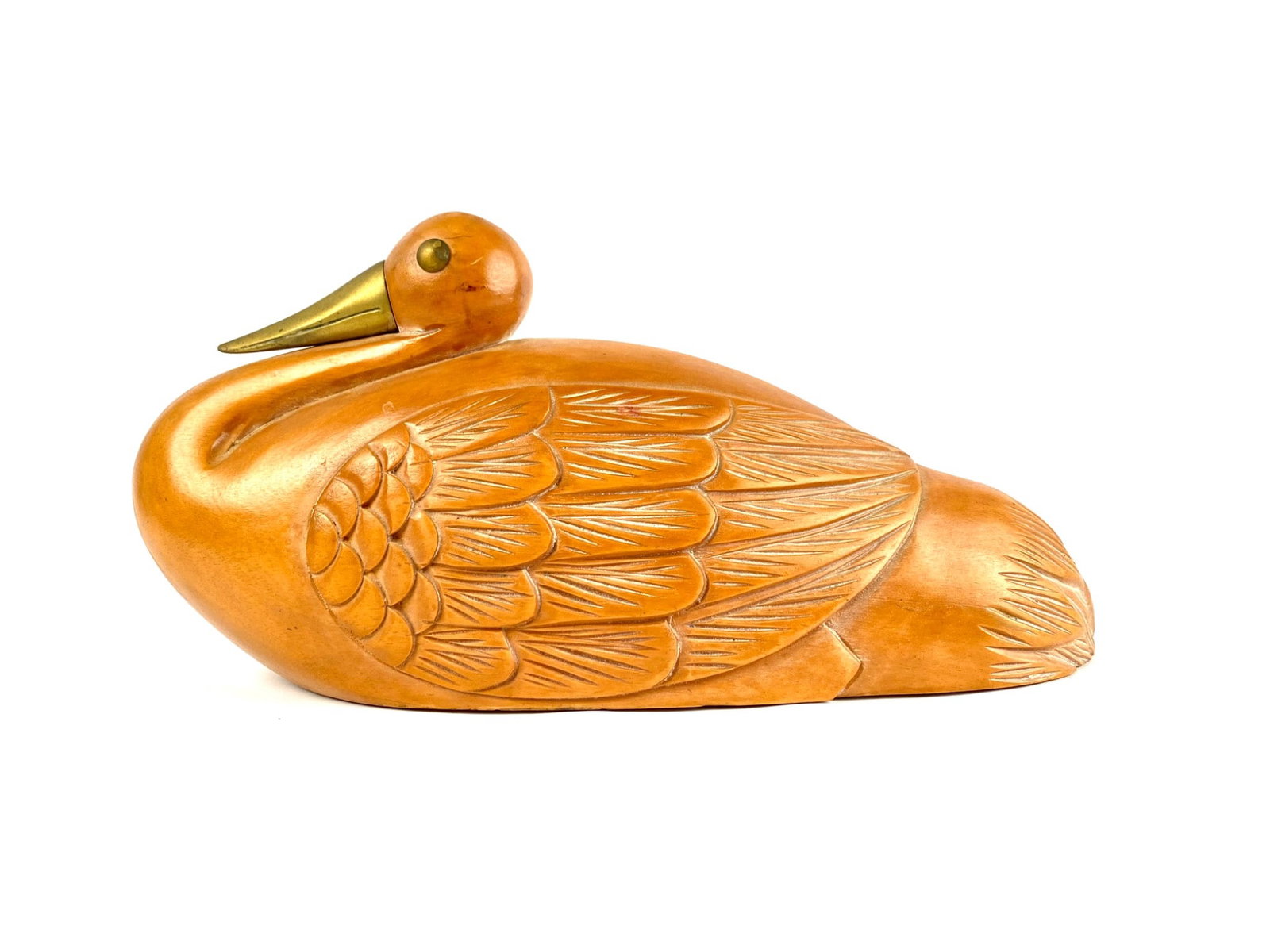 Hand-Carved Wooden Duck Figurine Fredrick Cooper: Hand-carved wooden duck figurine featuring finely detailed engraved feather patterns. The piece has a brass beak and eyes for added detail and texture. Has label on bottom saying Fredrick Cooper. Sign