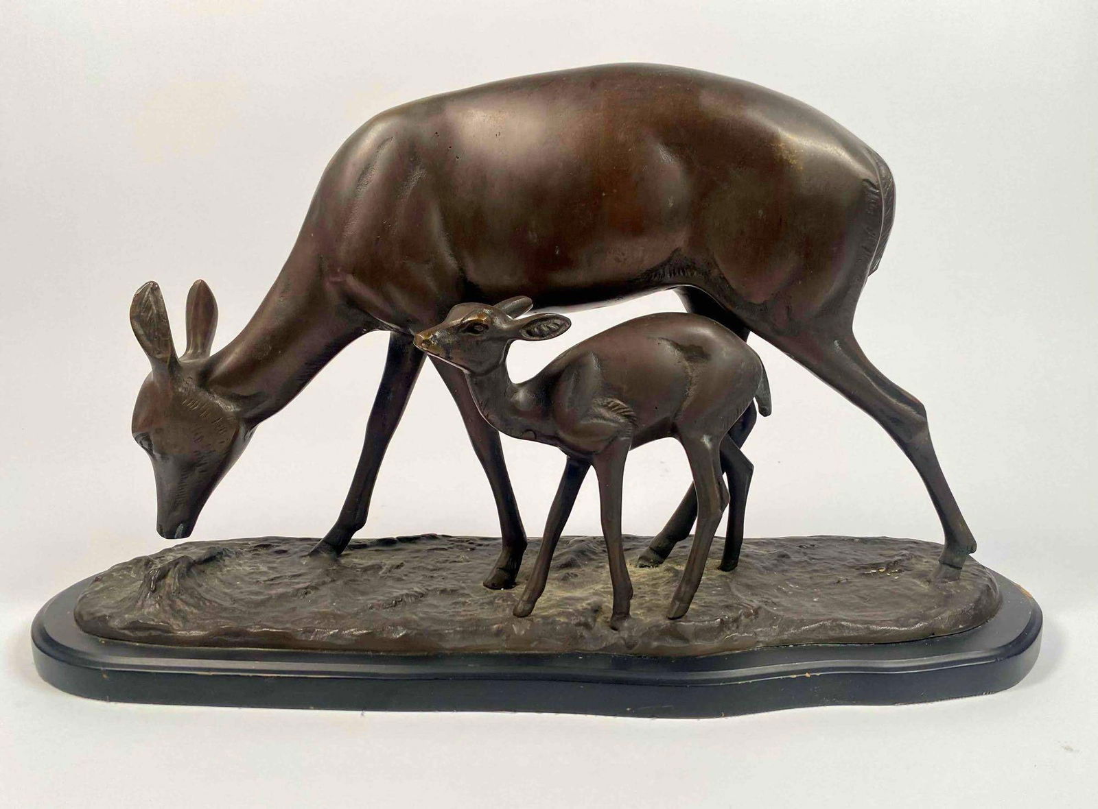 Bronze Deer and Fawn Sculpture Irenee Rochard: Bronze Sculpture resting on a wood base featuring a deer and young fawn by artist Irenee Rochard. Sturdy structure with a playful moment between deer and fawn. Small chip in found in the wood base nea