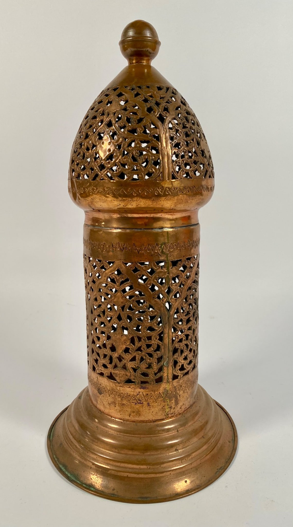 Pierced Brass Lantern with Floral Motifs and Base Stamp: A brass lantern with intricate floral motifs and geometric accents. Features a domed top with a knob finial and a decorative stamp on the underside, possibly identifying origin or maker. Has natural p