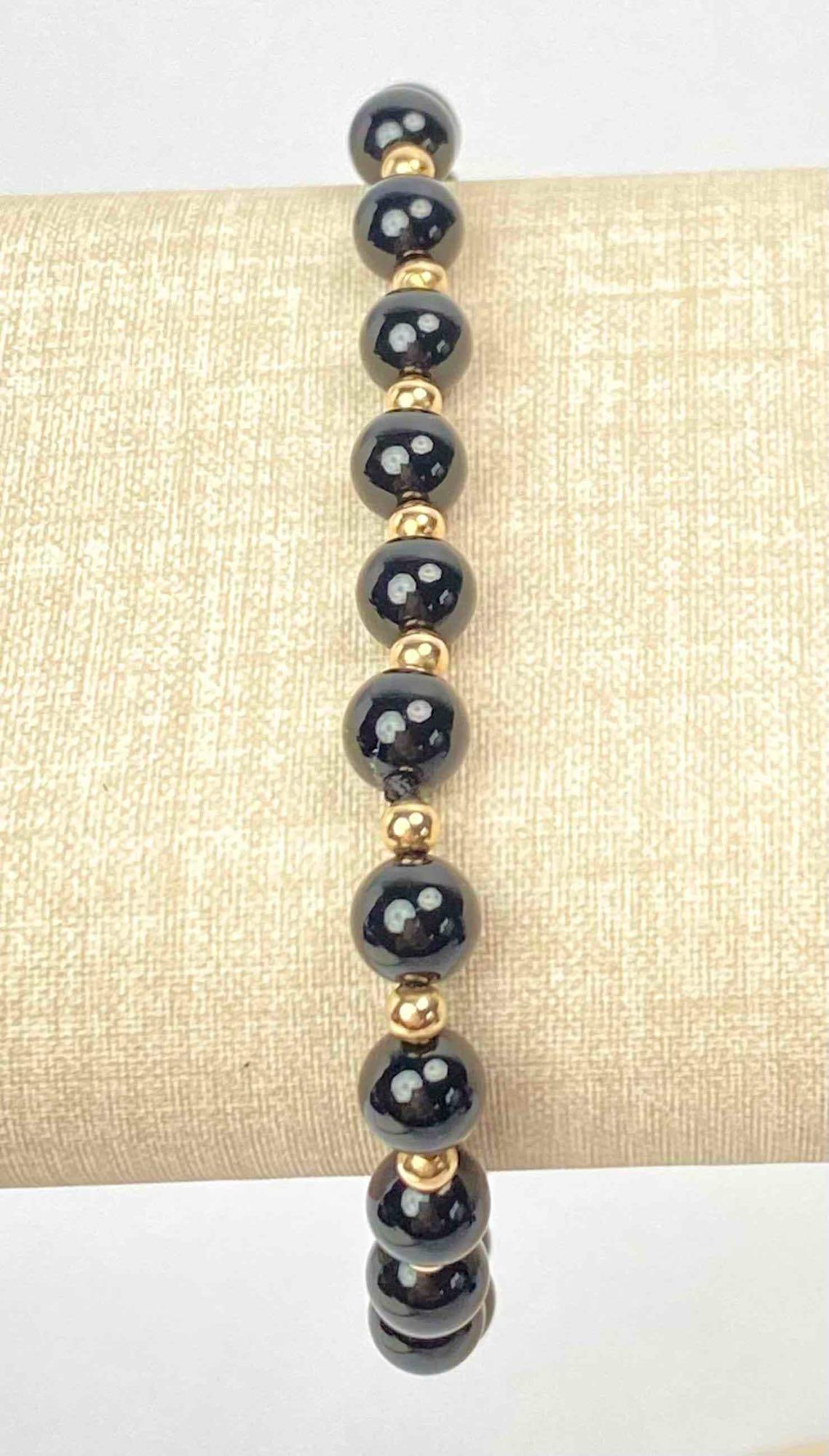 14k Gold and Black Onyx Hand-Tied Bracelet: 14k Gold and Black Onyx Hand-Tied Bracelet. Bracelet is in excellent condition. Please see photos for additional details. Length: 7.75" Total Weight: 77.29g Please note all lots show signs of wear com
