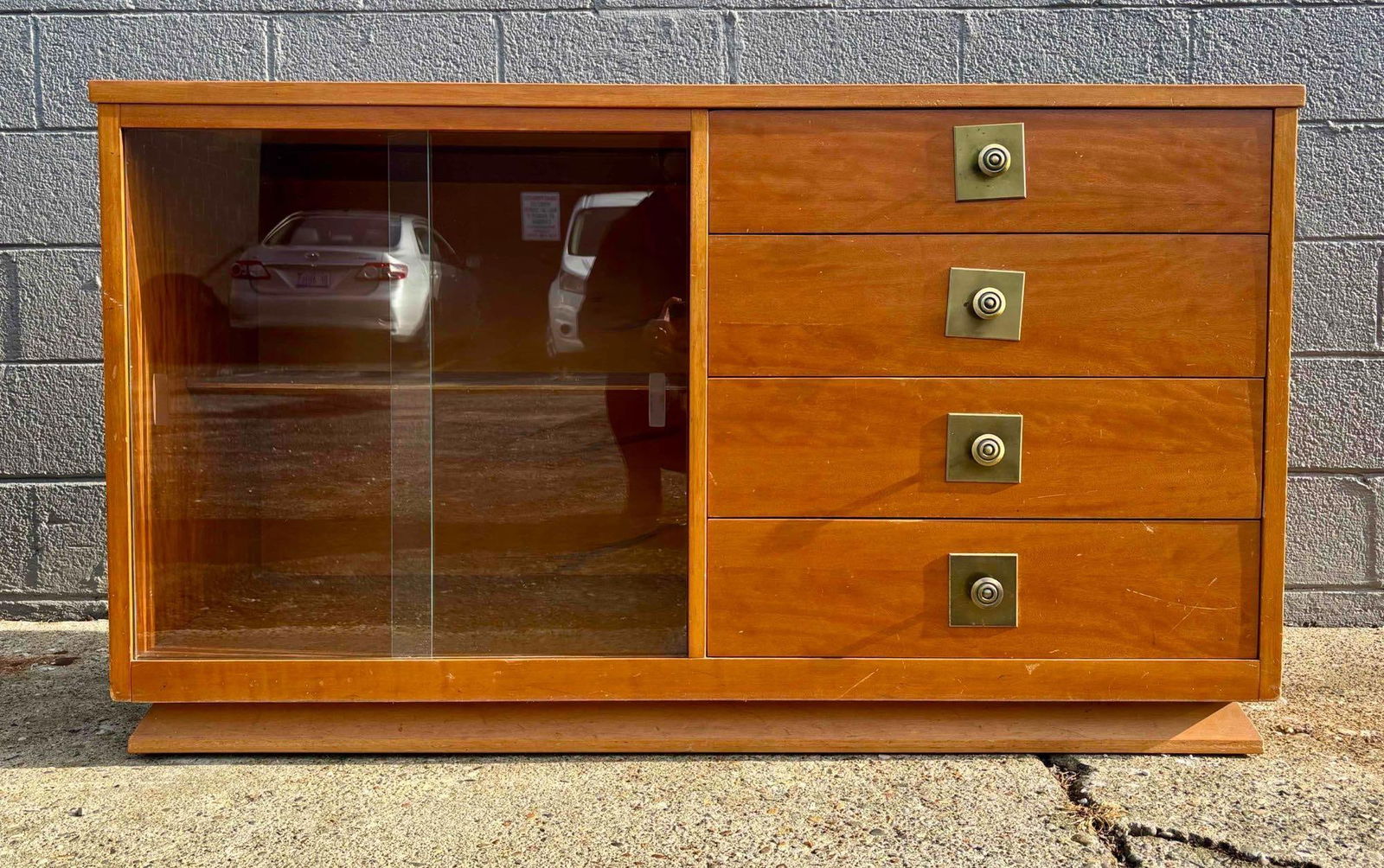 MCM Credenza: Mid century modern credenza with sliding glass doors and brass hardware. Credenza is in good condition with minor surface wear as pictured. Please see photos for additional details. Dimensions: 56" x
