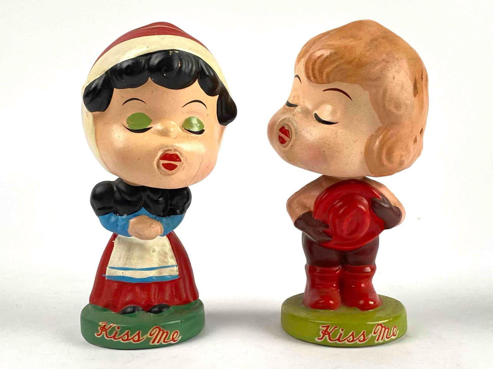 "Kiss Me" Bobblehead Figurines, Mid-20th Century: "Kiss Me" Bobblehead Figurines, Mid-20th Century. Lot is in good condition. Note: There are some fine scratches. Please see photos for additional details. Dimensions: 5" x 3" each Total Weight: 0.4lbs