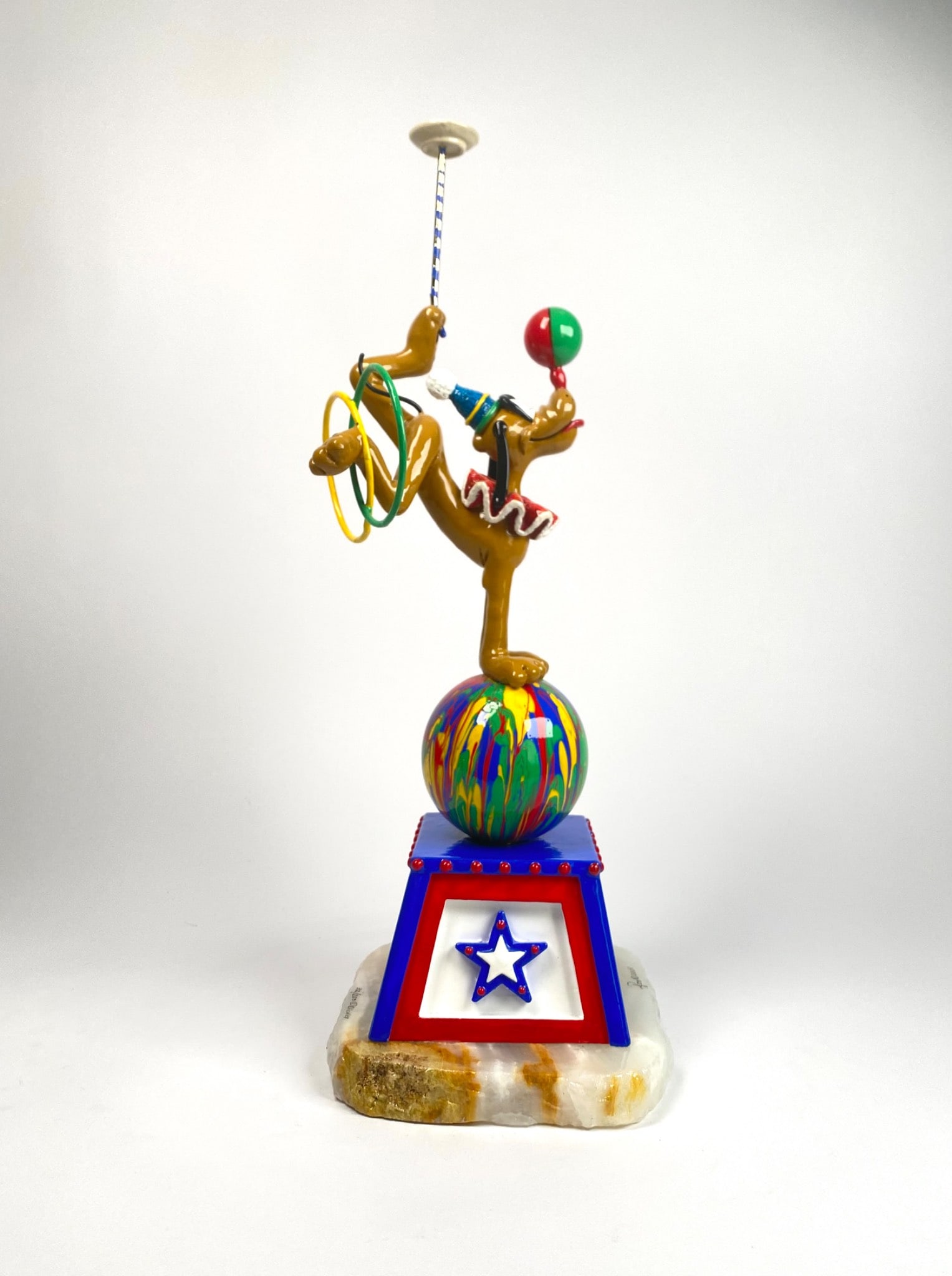 Ron Lee Circus Pluto (2005): Disney limited edition collectible sculpture featuring Pluto as a circus performer balanced on a colorful sphere atop a red, white, and blue base with a star emblem. Figure includes vibrant details su