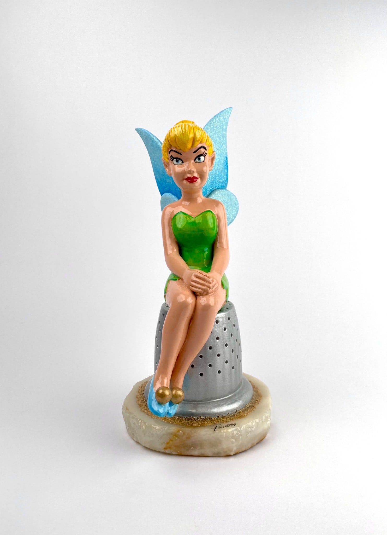 Ron Lee Tinker Bell Sculpture (1999): Limited edition hand-painted figurine of Disneyâ€™s Tinker Bell seated on a silver thimble by Ron Lee. Features glittered blue wings and a green dress. Base signed Ron with an edition