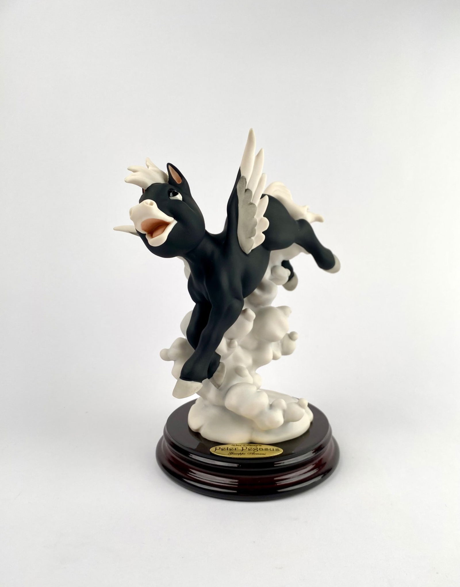Disney Peter Pegasus by Giuseppe Armani (Original Box): Porcelain and resin figurine titled Peter Pegasus, designed by Giuseppe Armani for Disney in 2004, crafted by Florence Studios. The piece features a black winged Pegasus frolicking on clouds, mounted