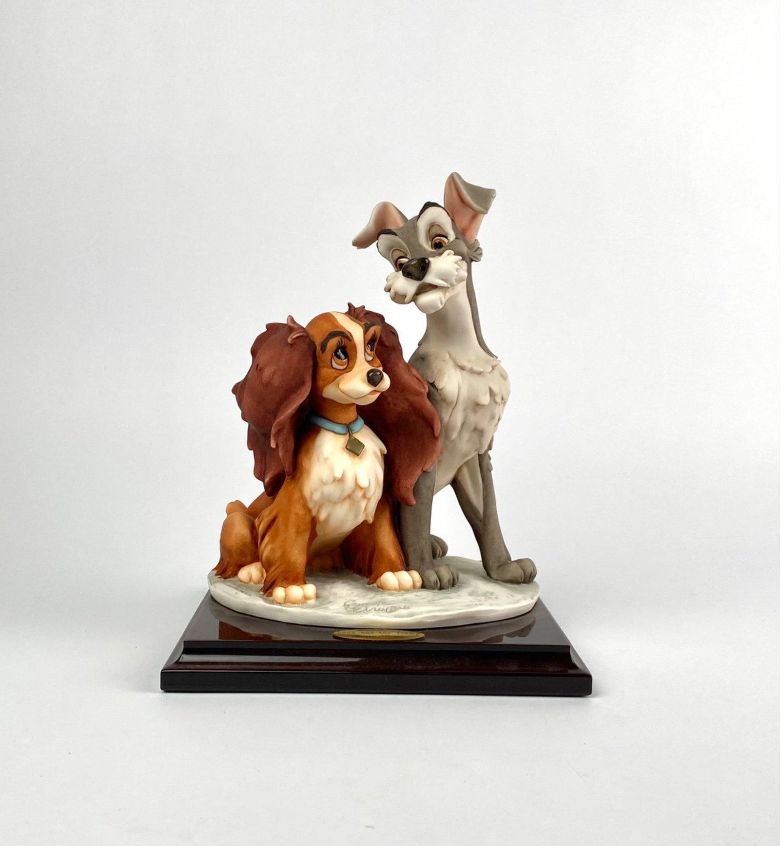 Disney Lady and Tramp By Giuseppe Armani (Original Box): Walt Disney Lady and the Tramp figurine by Giuseppe Armani. Crafted in 2003, this ceramic sculpture is mounted on a wooden base with a brass plaque reading the title and artistâ€™s na