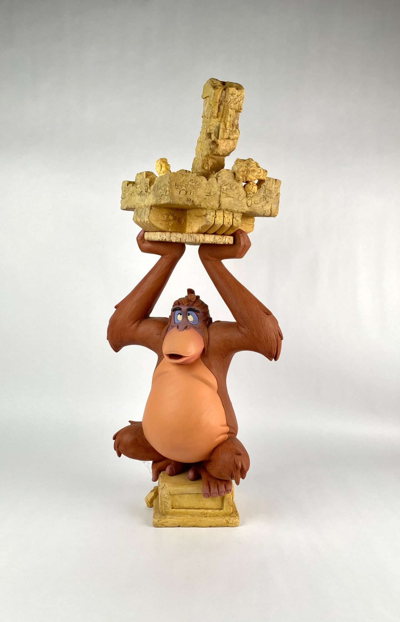 Disney Big FigÂ of King Louie Holding Ruins Base: Disney figurine depicting King Louie from The Jungle Book holding a detailed representation of crumbled ruins. The figure is crafted from painted resin material and marked Disney China at the base. Th