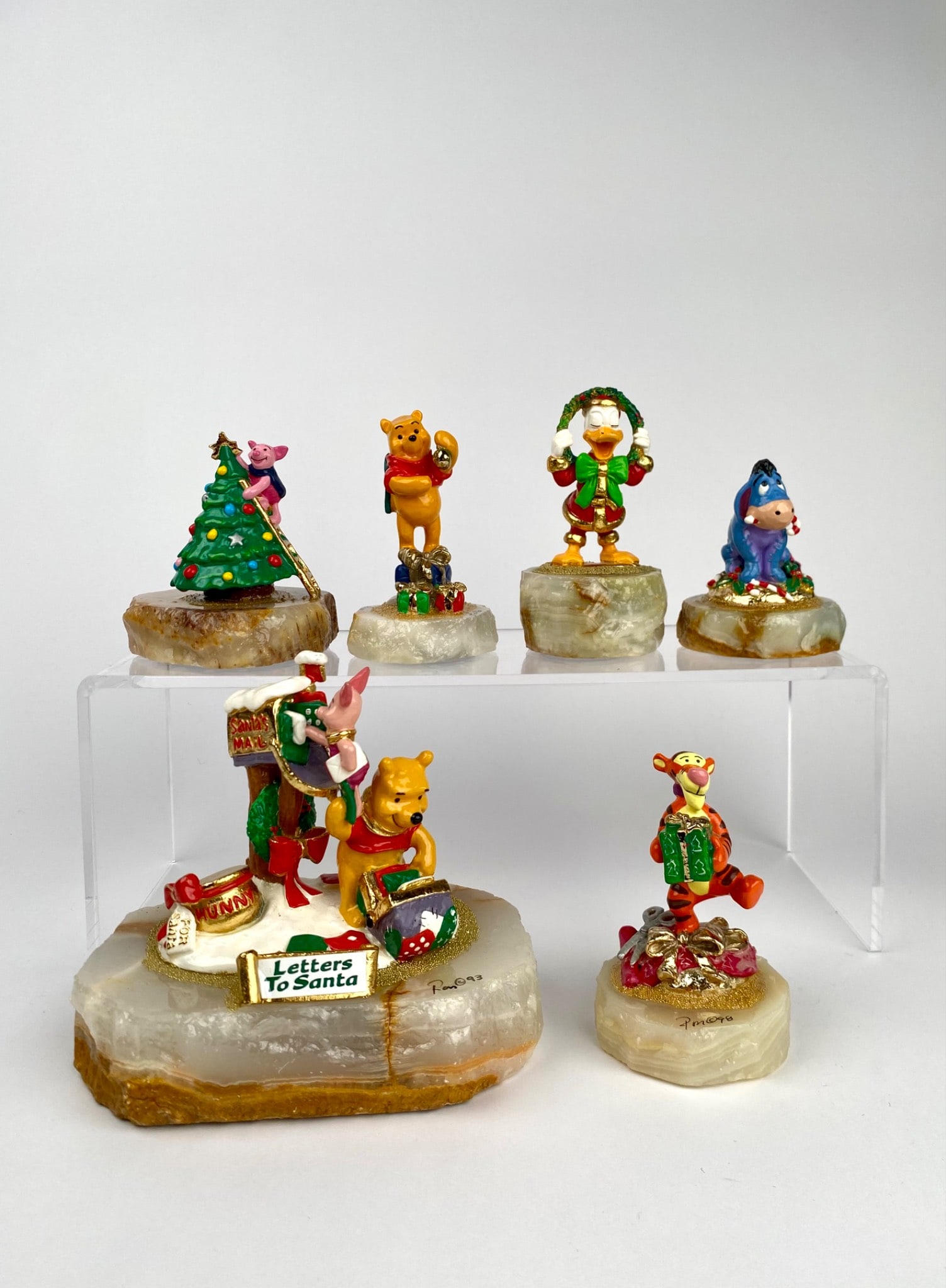 Ron Lee Disney Winnie the Pooh and Friends Christmas Set of Six: Set of six Disney Winnie the Pooh and Friends Christmas-themed figurines, featuring characters such as Winnie the Pooh, Piglet, Tigger, Eeyore, and Donald Duck in festive settings. Each figurine is mo