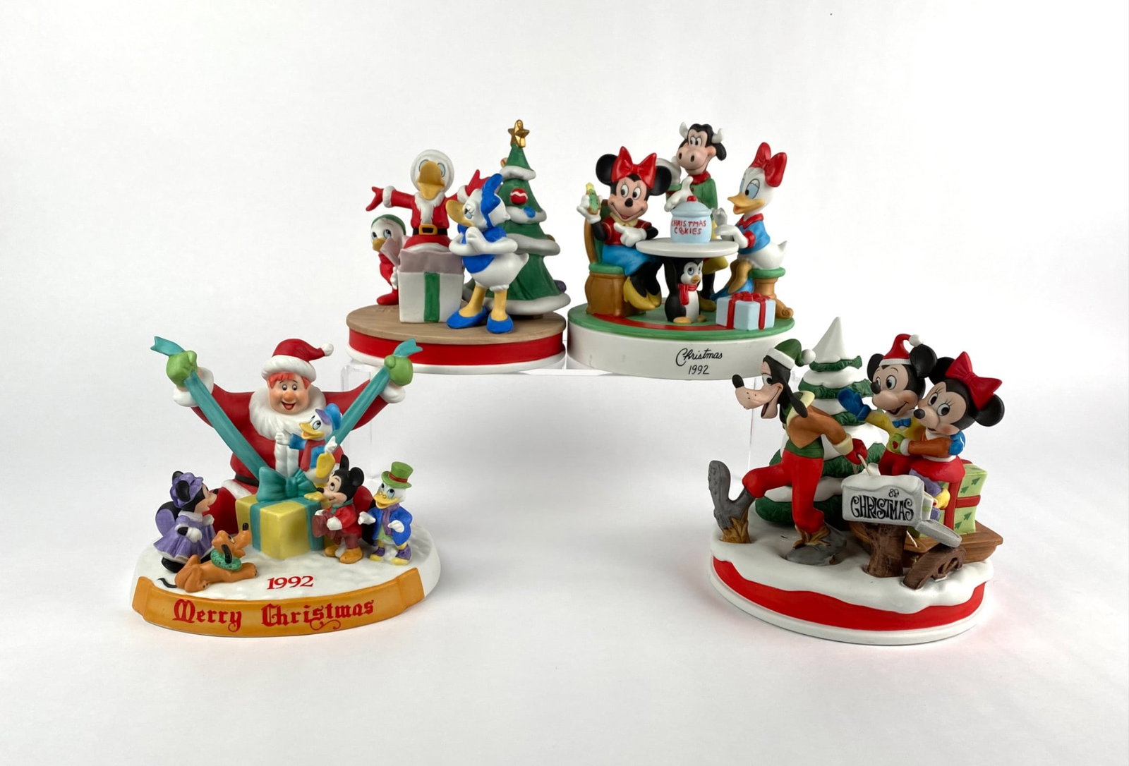 Set of Four Disney Christmas Figurines Limited Editions: A collection of four Disney Christmas figurines, each part of limited-edition runs, crafted by Walt Disney Artists and Grolier Collectibles Ltd. Figurines include The Sleigh Ride (1989), Christmas Coo