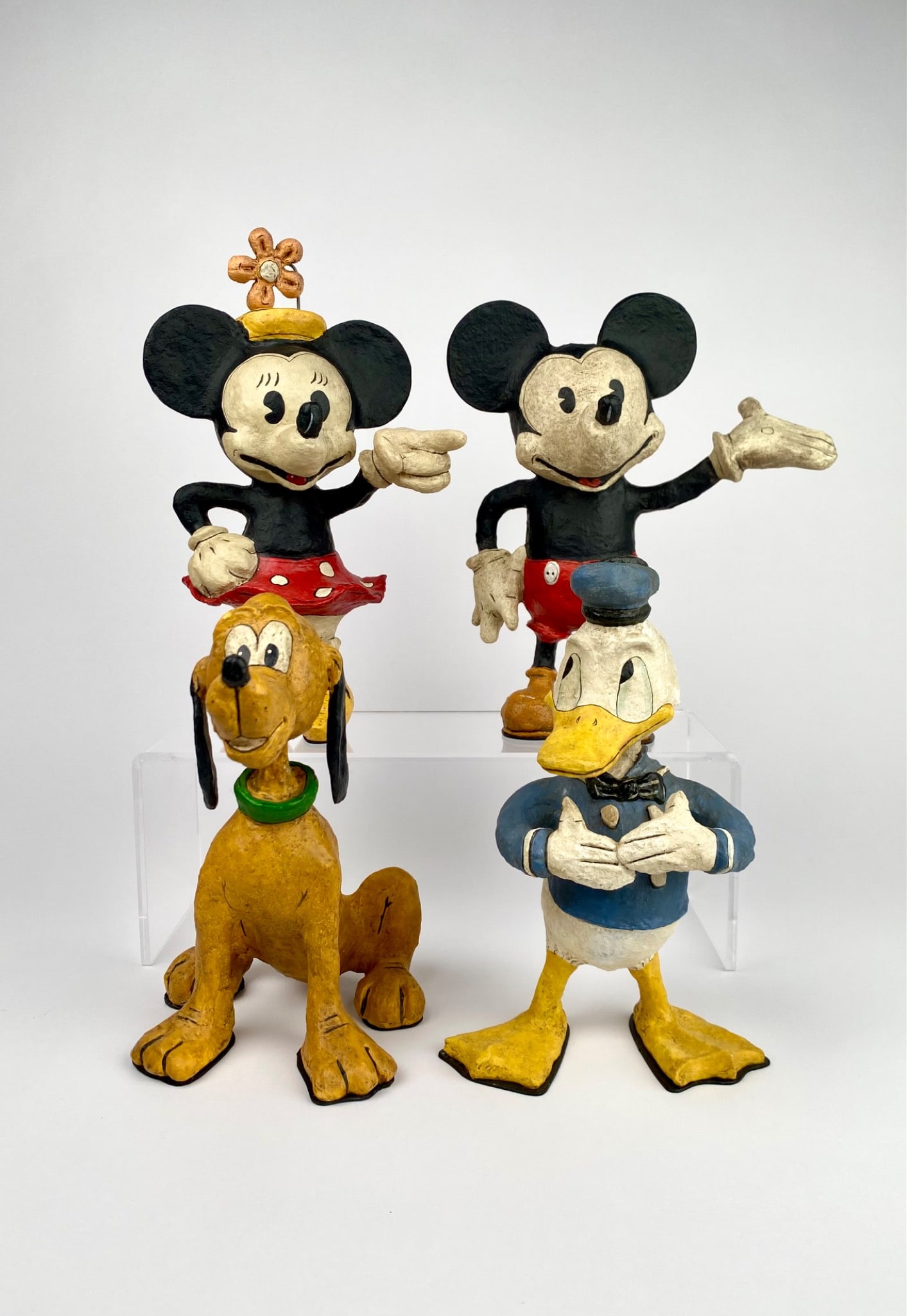 Four Poliwoggas David Critchfield and Vic Fortunato Disney Figurines: Set of four hand painted Disney inspired figurines comprising Mickey Mouse, Minnie Mouse, Donald Duck, and Pluto. Each reproduction piece is stamped Poliwoggas with additional markings on the base. De