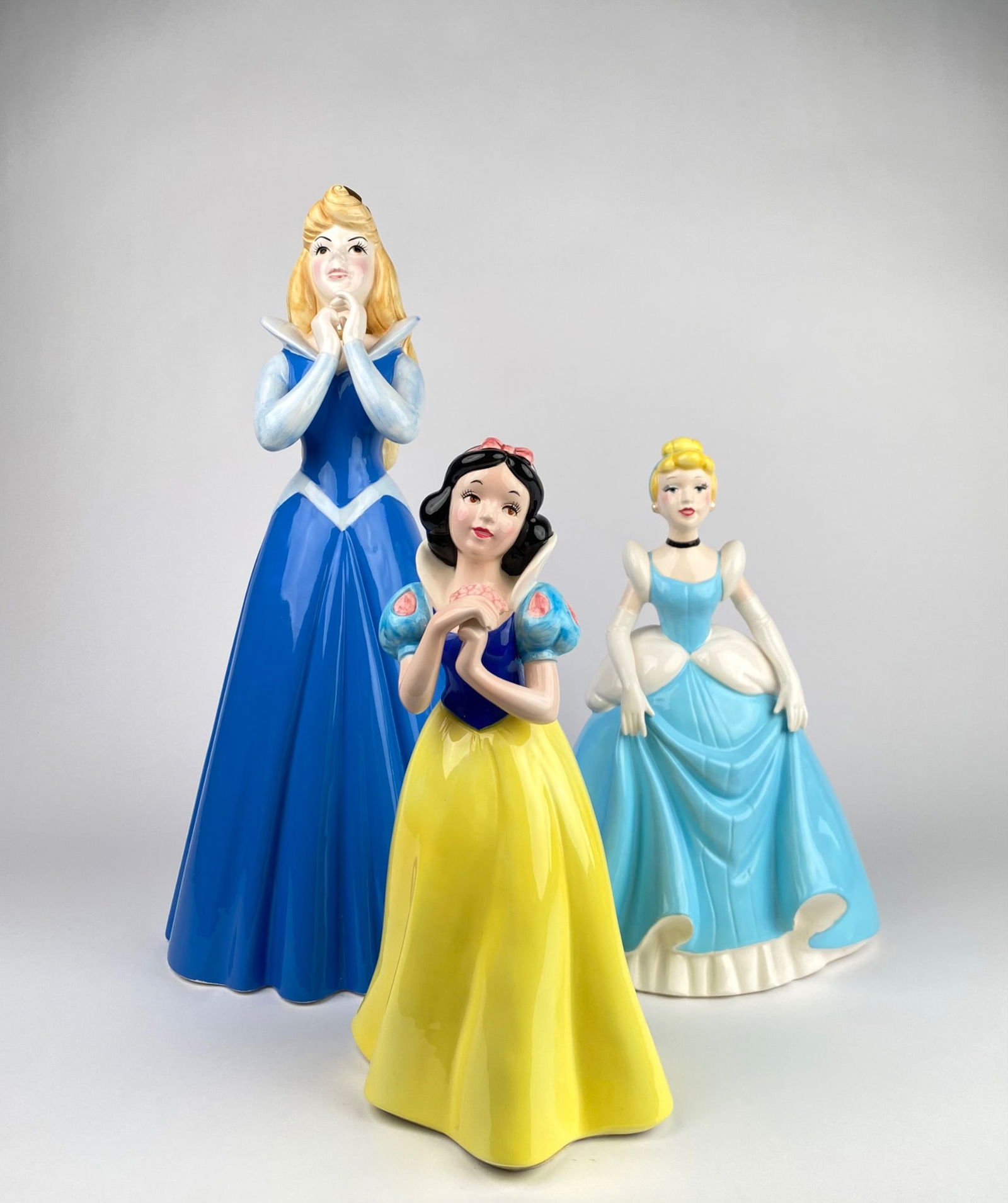 Set of 3 Large Disney Schmid Ceramic Musical Figurines: Set of three Disney Schmid ceramic musical figurines featuring Sleeping Beauty, Cinderella, and Snow White. Each figurine showcases detailed craftsmanship, with the Sleeping Beauty figurine marked Sch