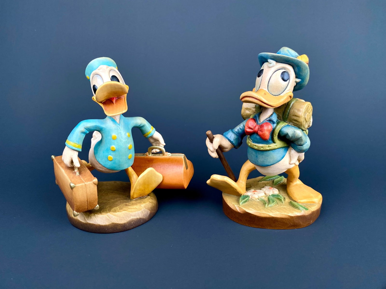 Pair of Disney Donald Duck Figurines by ANRI: Pair of limited edition Donald Duck figurines by ANRI. Includes Hiker Donald, marked 139 out of 500, and Bellboy Donald, marked 147 out of 500. Both are crafted in high quality material with detailed 