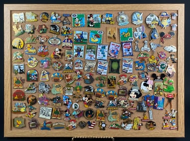 Collection of Disney-Themed Enamel Pins Displayed on Cork Board