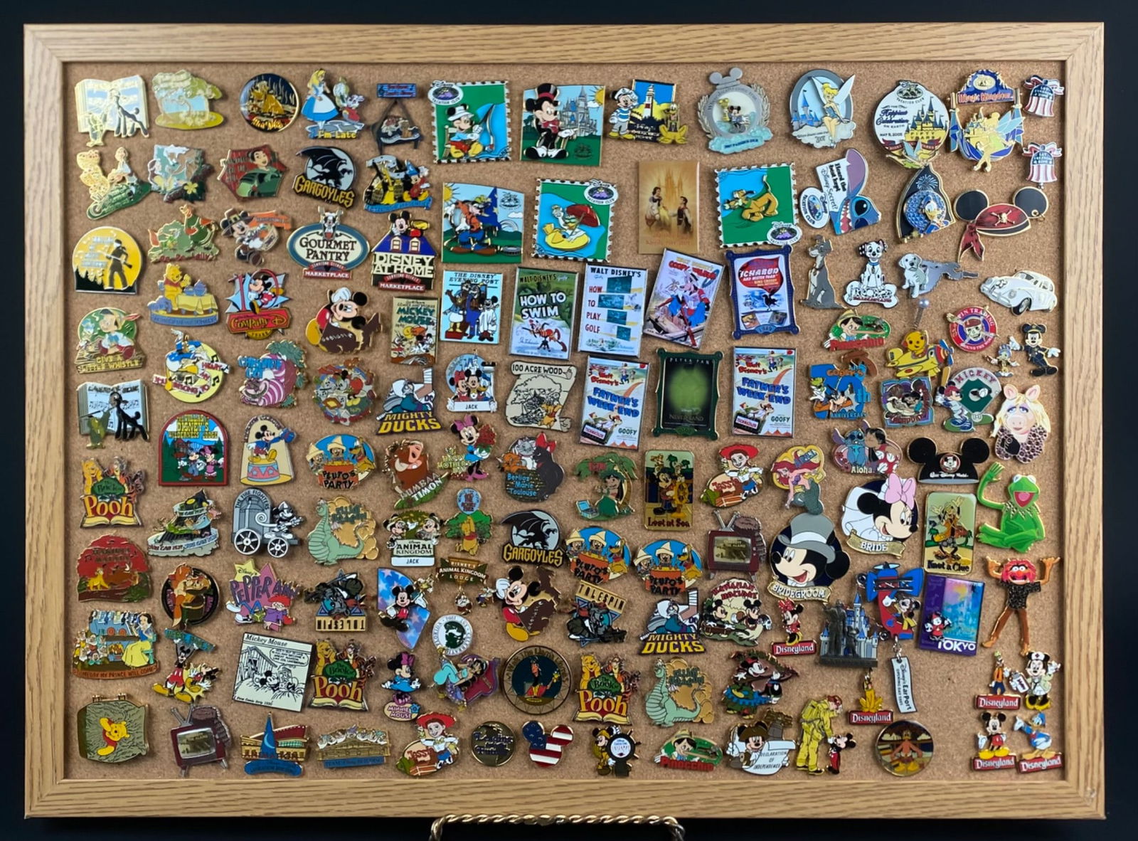 Collection of Disney-Themed Enamel Pins Displayed on Cork Board (1 of 12)