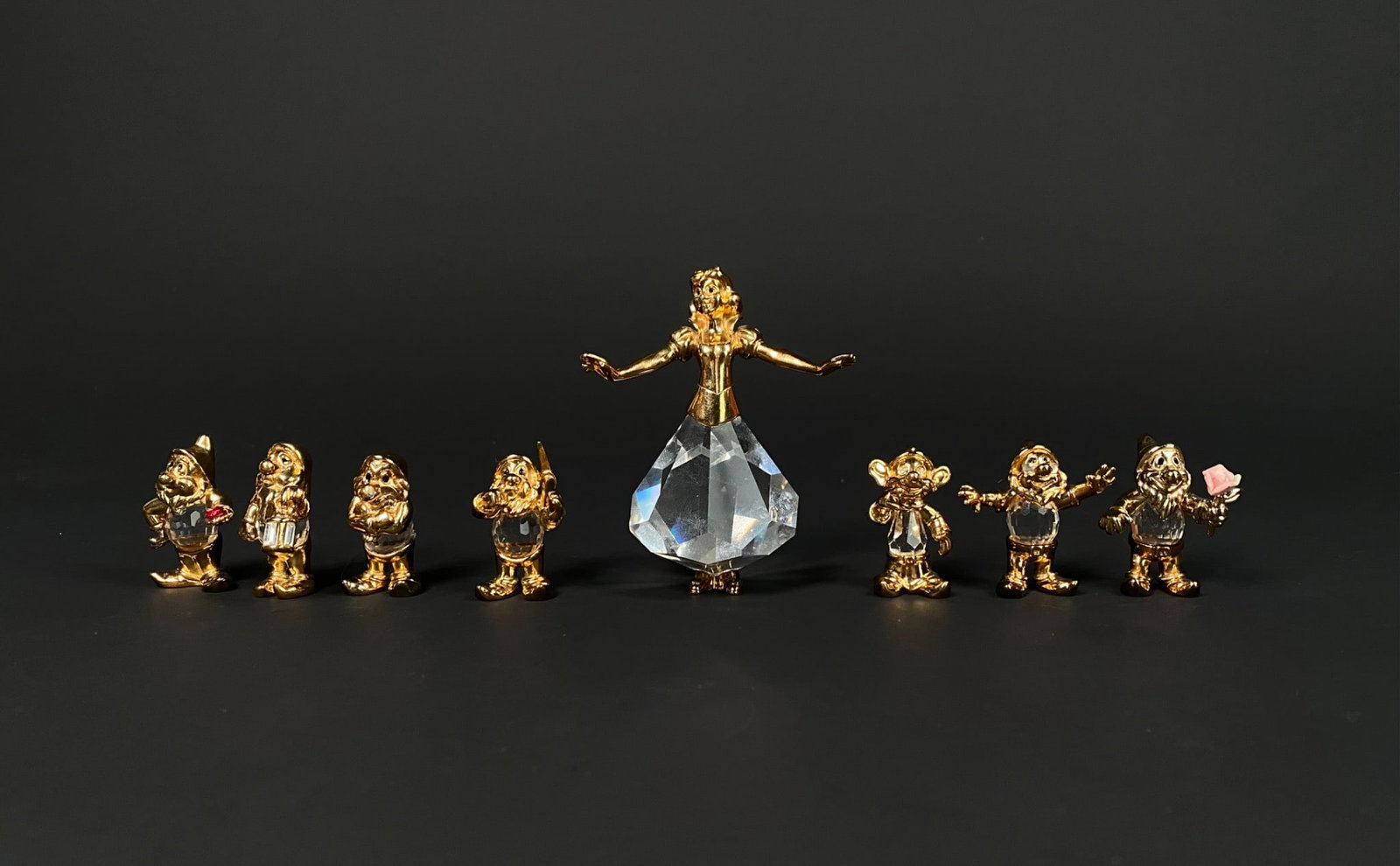 Gold and Crystal Figurine Lencia Snow White and Seven Dwarfs: Gold-plated and crystal figurine set inspired by Snow White and the Seven Dwarfs, comprising Snow White with a faceted crystal skirt and eight dwarfs, each sporting clear crystal bodies with hand-pain