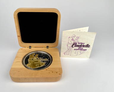 Disney Cinderella 50th Anniversary Gold Select Fine Silver Coin (COA): Five troy ounce .999 fine silver coin with 24kt gold select design commemorating the 50th Anniversary of Walt Disneys Cinderella. Features the iconic image of the Prince and Cinderella on one side and