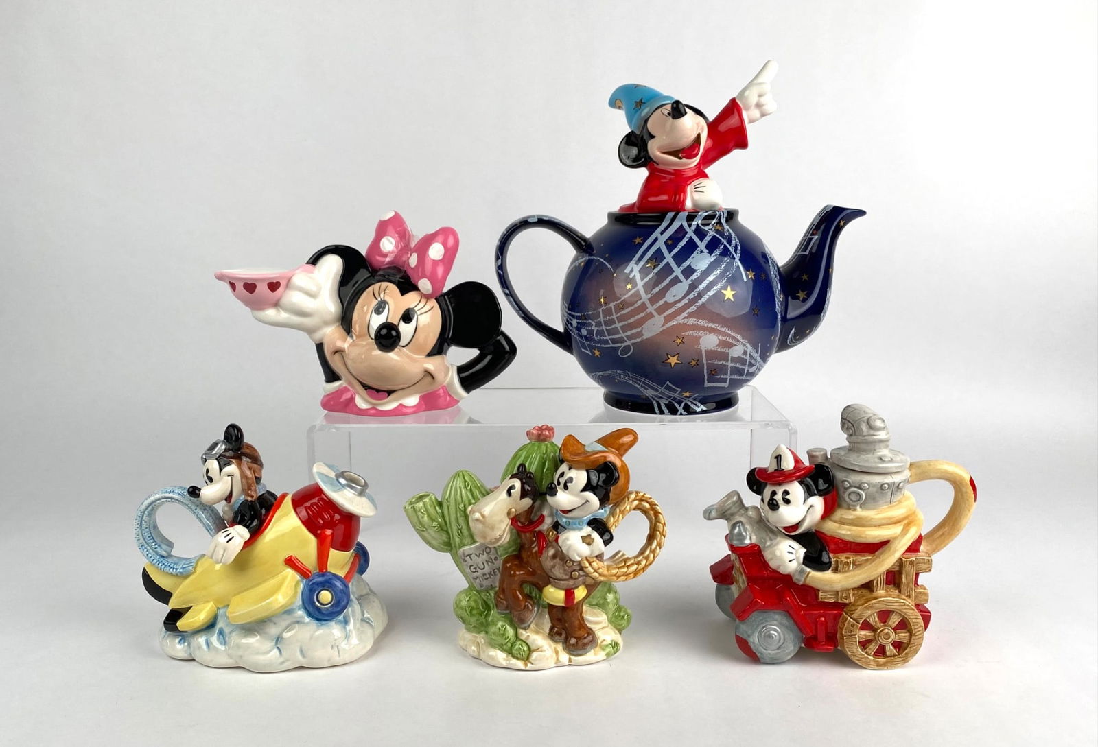 Set of Disney Themed Ceramic Teapots and Teapot Figurines by Enesco: Set of five Disney themed ceramic teapots and teapot figurines designed by Enesco. Each piece features Mickey Mouse or Minnie Mouse in various designs, including The Mini Pilot, Two Gun Mickey, a fire