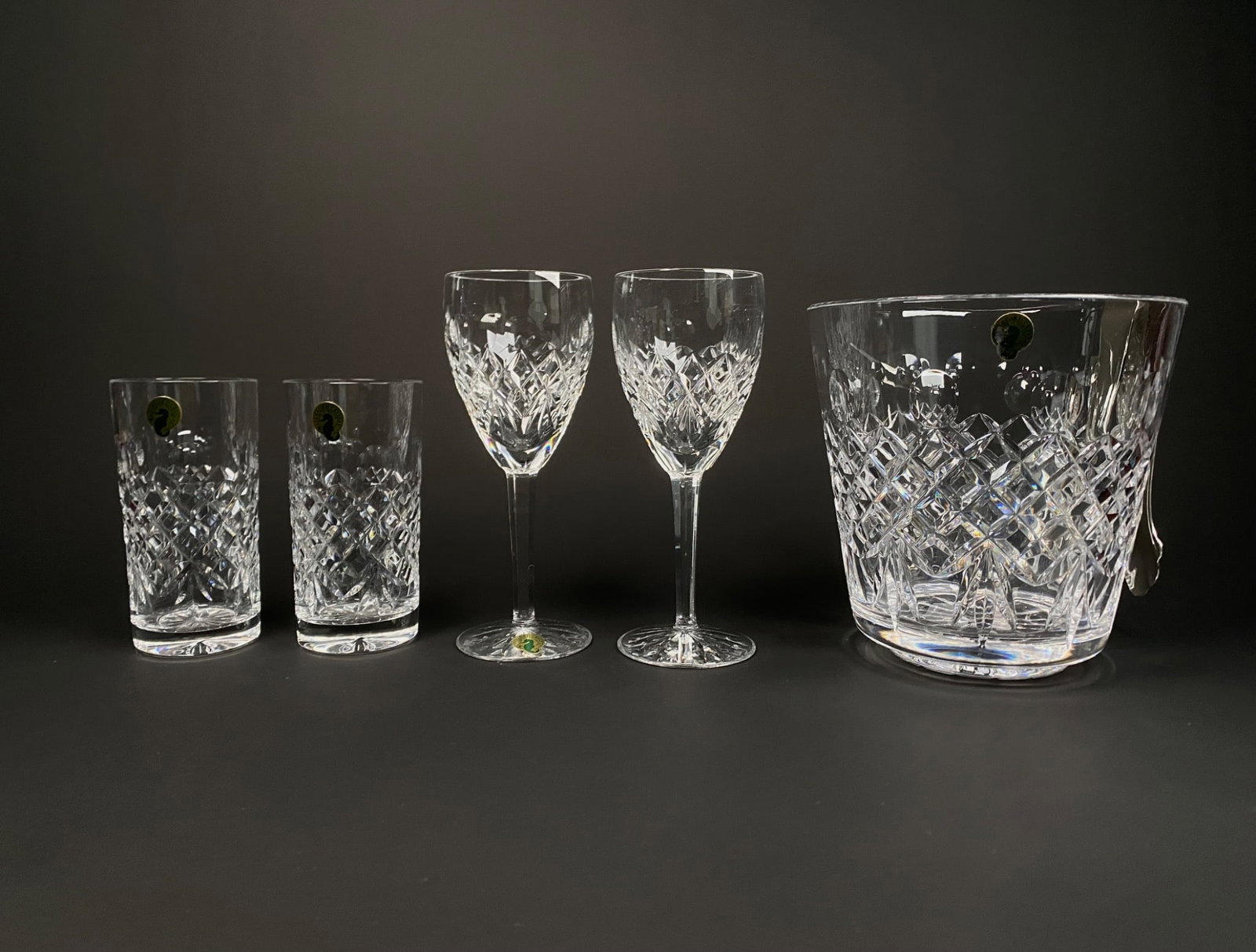 Waterford Crystal Disney Mickey Barware Set with Ice Bucket: Waterford Crystal barware set featuring designs inspired by Disney’s Mickey Mouse. The set includes two wine glasses, two highball glasses, and an ice bucket with accompanying tongs. Each item is cr
