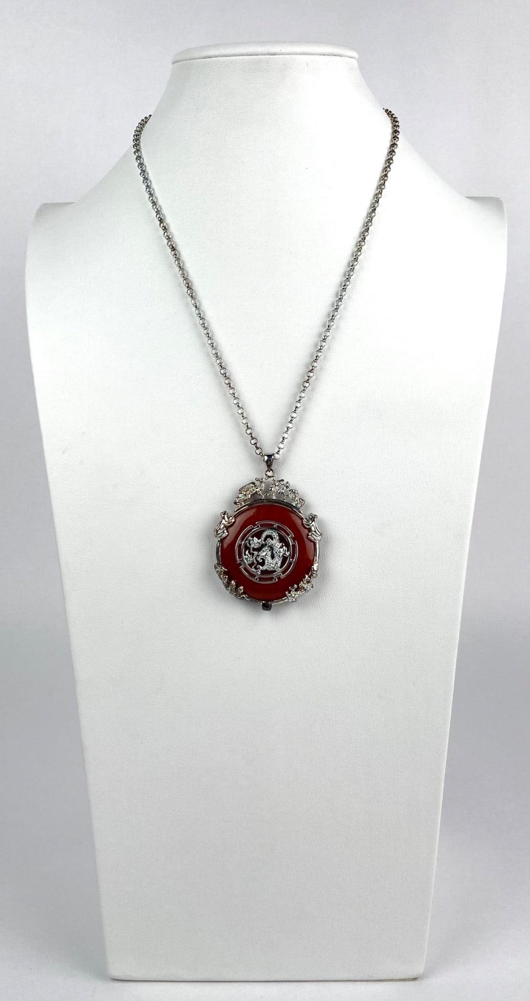 Sterling Silver Necklace with Red Jasper Pendant: Sterling silver pendant necklace featuring a red jasper circular centerpiece with intricate silver tone dragons and decorative borders. The necklace has an Italian adjustable chain with a secure clasp
