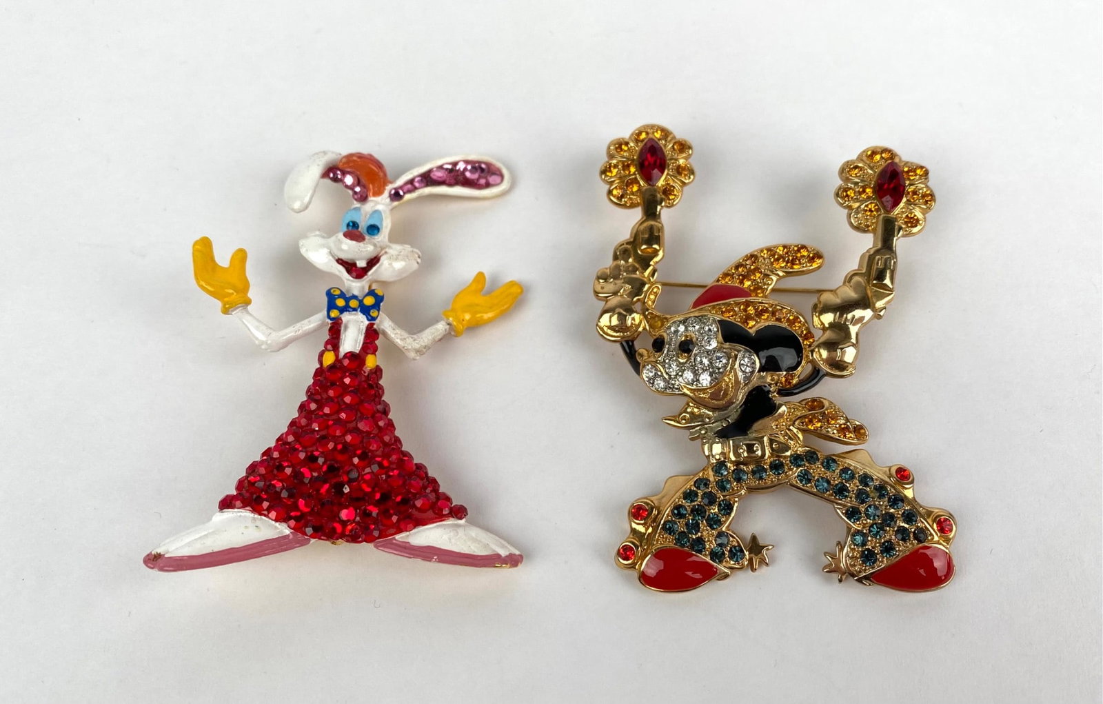 Pair of Disney Character Brooches Roger Rabbit and Mickey Mouse: Pair of Disney themed brooches comprising a Roger Rabbit brooch adorned with red crystal accents and colorful enamel, and a Mickey Mouse brooch embellished with multicolored rhinestones and gold toned