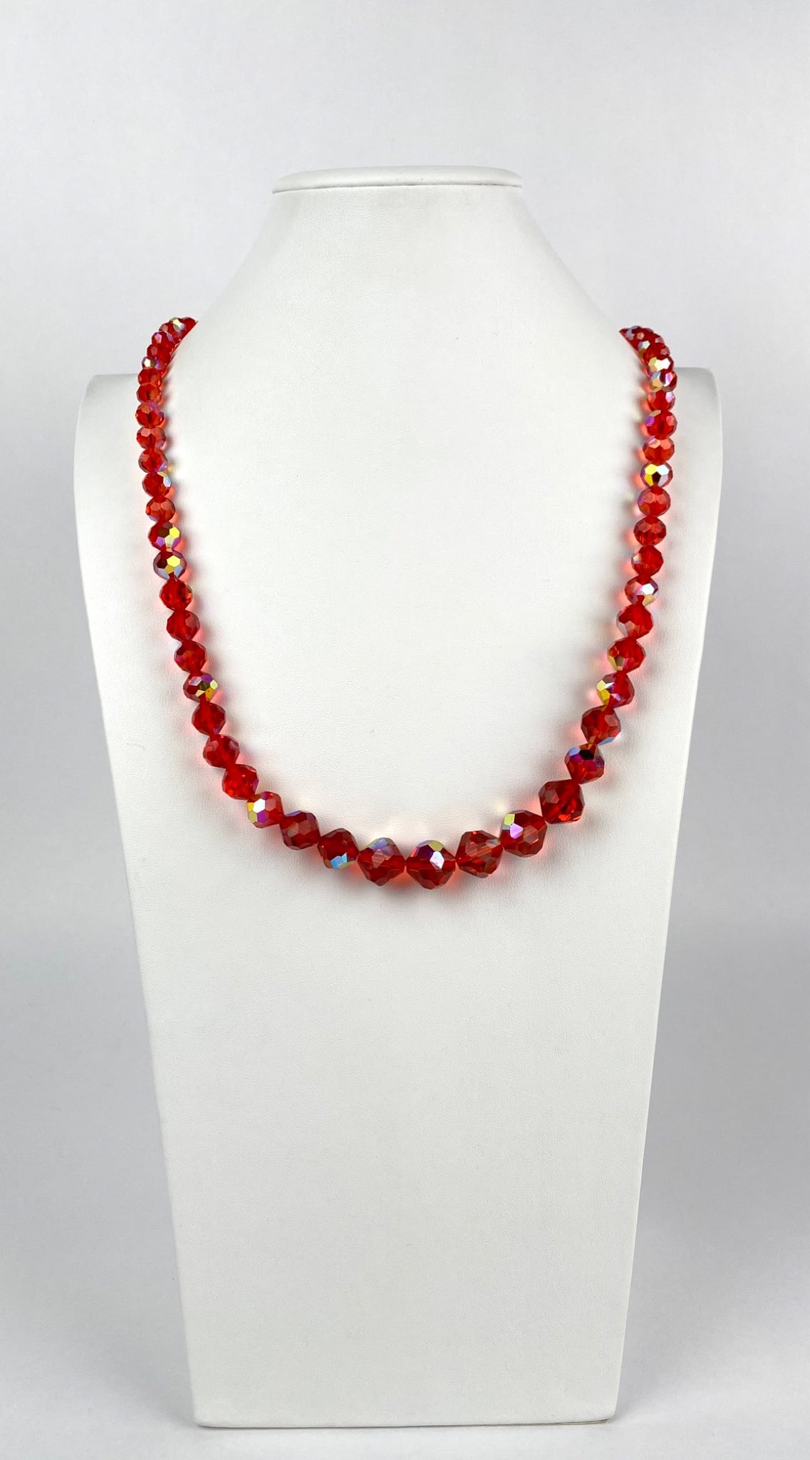 Vintage Faceted Red Crystal Bead Necklace with Gold Tone Clasp: Faceted red crystal bead necklace featuring a gold-tone spring ring clasp. The beads display an aurora borealis finish, creating a reflective and shimmering effect. All components are in functional co