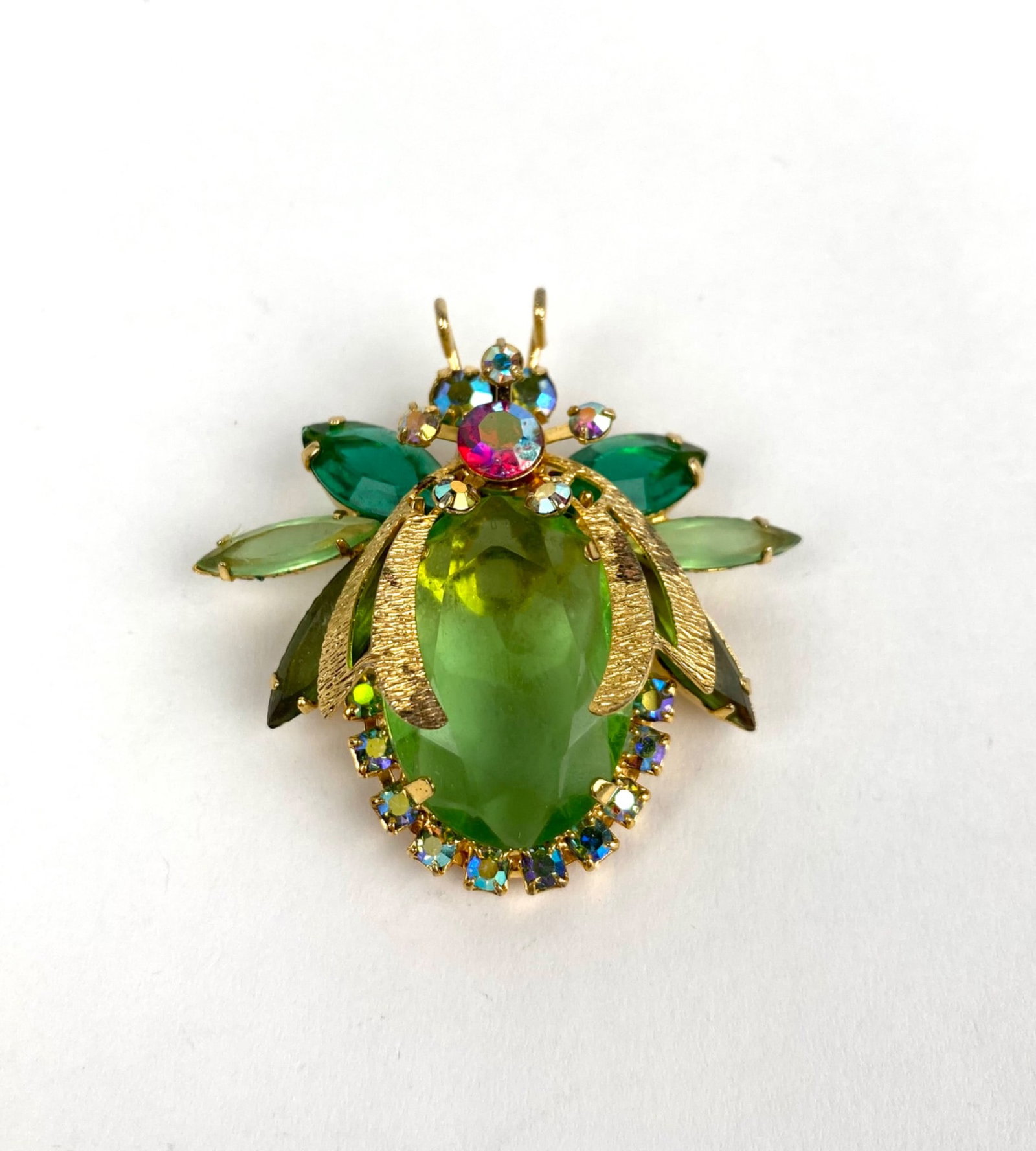 Vintage Juliana Beetle Brooch: Gold tone brooch designed in a beetle shape, featuring a large green rhinestone at the center, complemented by green and multicolored rhinestones on the wings and body. Includes an intricate filigree 