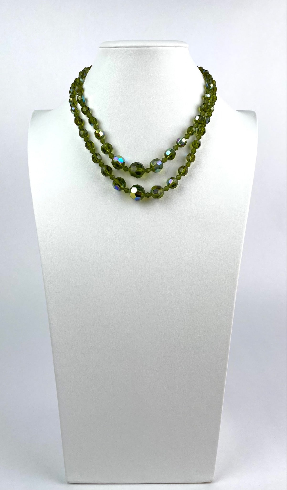 Double Strand Green Crystal Beaded Necklace with Hook Clasp: Double-strand necklace featuring green faceted glass beads with an iridescent finish. The necklace is secured by a hook clasp and features polished, reflective beads with coloring that reflects light