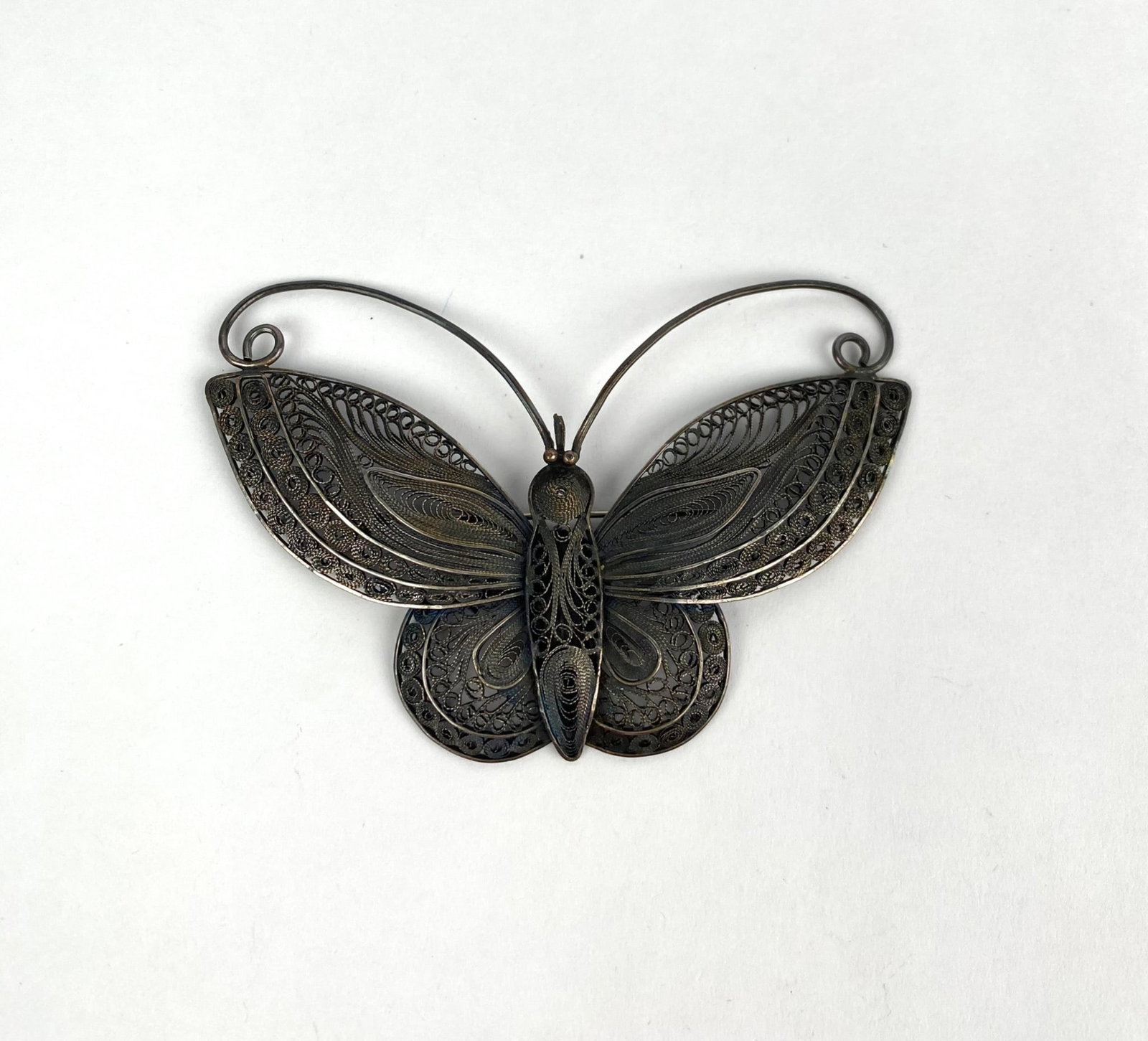 Sterling Silver Filigree Butterfly Brooch, Stamped 925: Sterling silver butterfly shaped brooch with intricate filigree work. Features a secure pin mechanism on the back and is stamped 925 for sterling silver purity. Lightweight and delicate design, showca