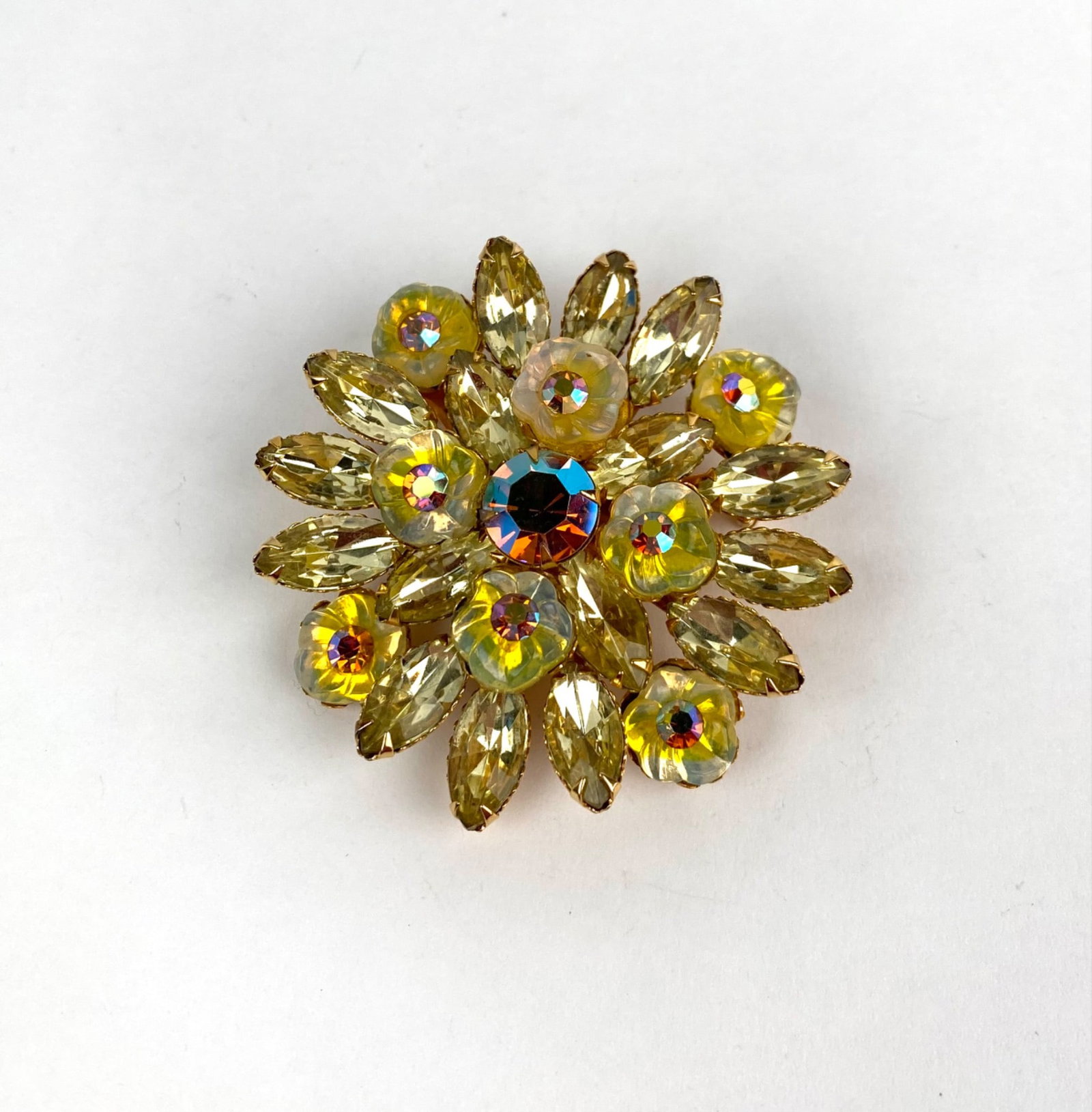 Vintage Gold Tone Brooch With Yellow Rhinestones: Gold tone floral brooch featuring a design of marquise shaped yellow rhinestones and round aurora borealis accents. The brooch has a secure pin back closure. Wear consistent with age and use. Dimensio