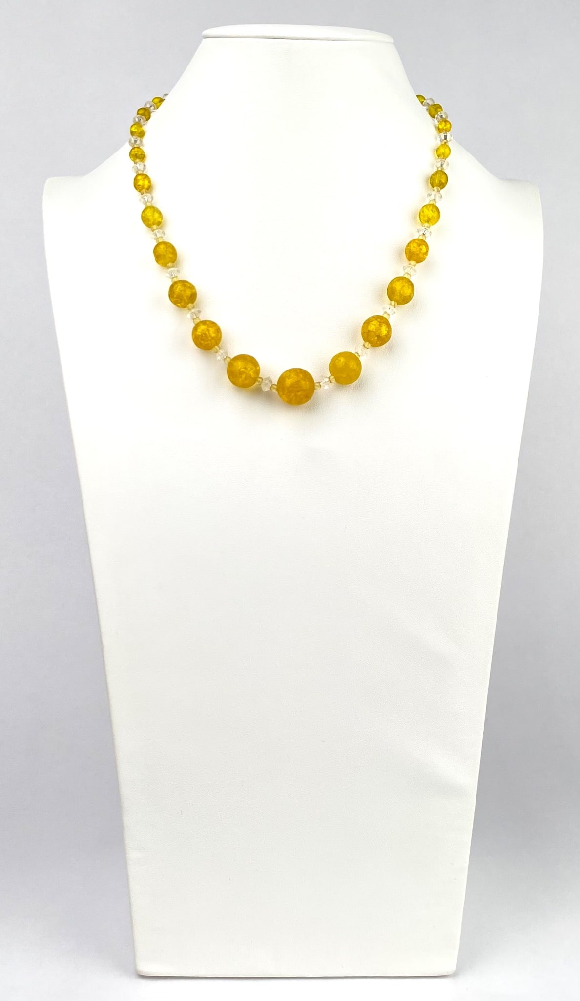Early 20th Century Czech Yellow and Clear Glass Beaded Necklace: Necklace featuring yellow glass beads with a crackle finish paired with clear beads. Secured by a metal clasp bearing an engraved detail, indicative of the maker. The beads are uniformly arranged, cre