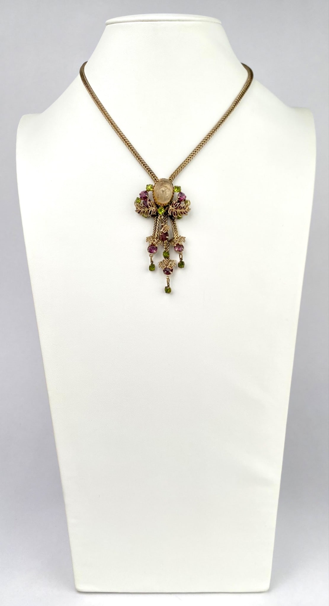 Victorian Revival Necklace with Molded Glass Pendant: This is a vintage Czech Victorian Revival necklace featuring a central molded glass intaglio cameo surrounded by ornate filigree metalwork. Accented with prong-set faceted glass stones in soft amethys