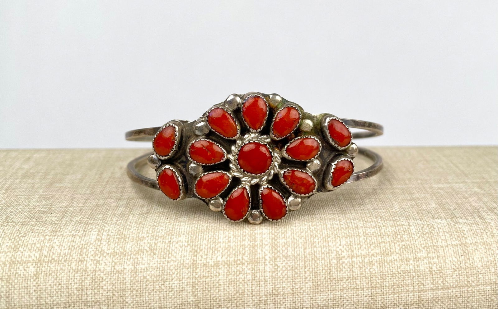 Sterling Silver and Coral Cluster Cuff Bracelet Marked PLN: Sterling silver cuff bracelet with a central floral cluster design featuring red coral stones. The bracelet is marked PLN on the back. Exhibits a double band cuff construction. Cuff is in good conditi