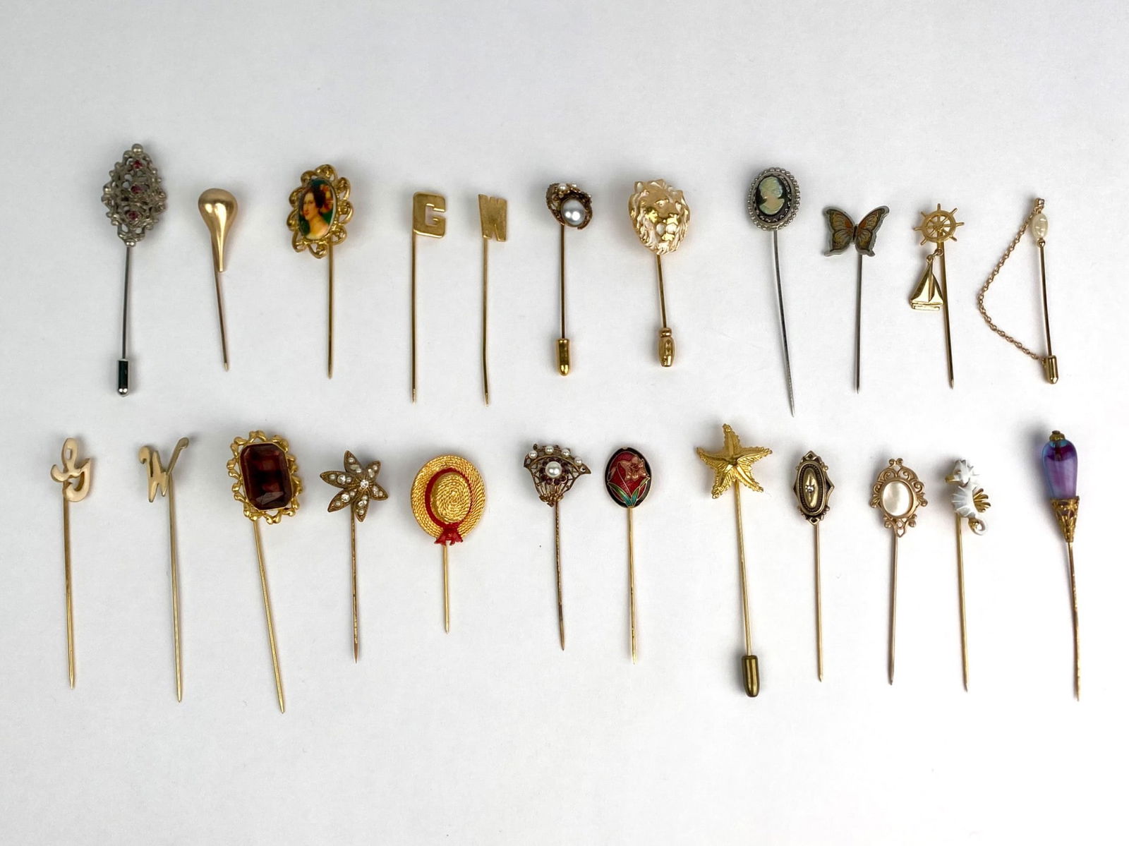 23 Antique and Vintage Stick Pins: Collection of 23 vintage and antique stick pins, each with a unique motif. The set includes figural, floral, nautical, cameo and monogrammed designs crafted in a range of finishes including gold tone,
