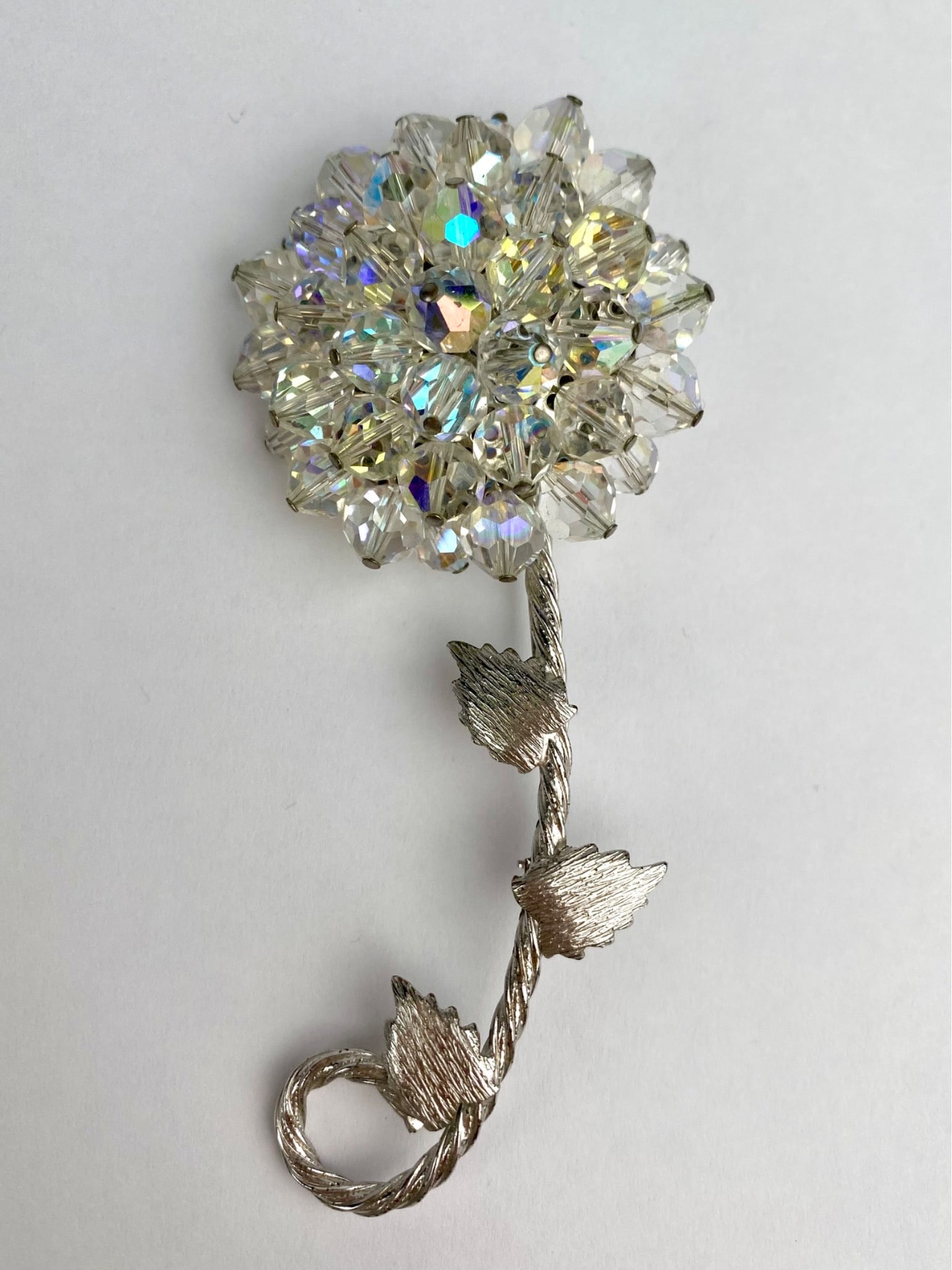 Vintage Aurora Borealis Crystal Beaded Flower Brooch: Vintage brooch designed in the shape of a blooming flower, featuring a dazzling cluster of faceted Aurora Borealis crystal beads that shimmer with iridescent color. The three dimensional bloom sits at