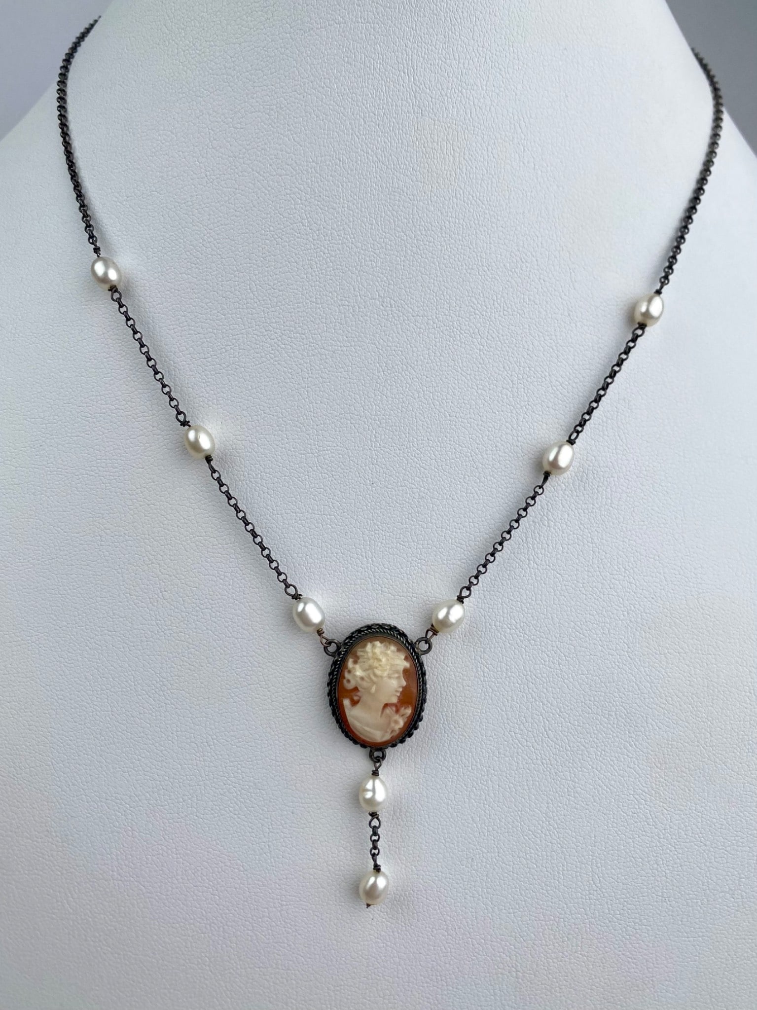 Sterling Silver Italian Cameo and Freshwater Pearl Necklace: Sterling silver necklace featuring a carved shell cameo set in an oxidized bezel and accented by freshwater pearls. The centerpiece cameo depicts a classical female profile and is further adorned by a