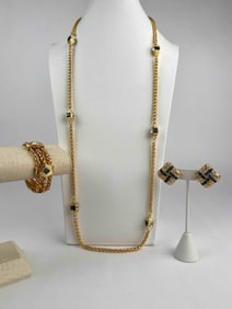 This is a signed Nolan Miller jewelry set featuring a long gold-tone rope chain necklace with