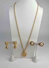 This is a signed Nolan Miller set featuring a gold-tone rope chain necklace with a dimensional