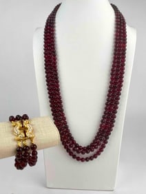 Nolan Miller jewelry set featuring a three-strand garnet-colored beaded necklace paired with a