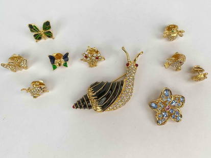 Whimsical lot of ten Nolan Miller pins featuring a vibrant variety of designs. The collection: Whimsical lot of ten Nolan Miller pins featuring a vibrant variety of designs. The collection includes a rhinestone encrusted snail with black enamel detailing, a pastel blue and pink crystal star flo