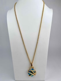 Signed Kenneth Jay Lane necklace featuring a faceted blue crystal pendant wrapped in sculptural gold