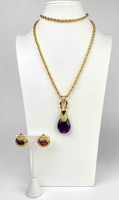 Nolan Miller gold tone necklace and clip on earrings. Necklace has a large purple pendant and