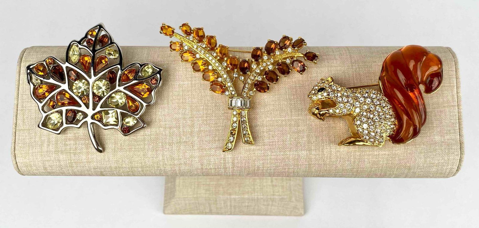 Lot of three brooches by Nolan Miller. One brooch is a squirrel brooch with gold tone metal, (1 of 11)