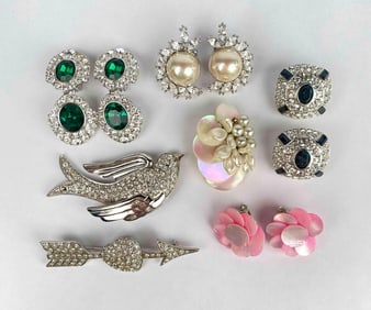 Assorted lot of costume jewelry including items from Nolan Miller. Lot includes 2 brooches, 4 pairs