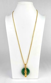 Gold tone necklace with round green stone pendant. Necklace clasp is hallmarked with K.J.L. as