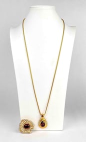 Gold tone necklace and brooch with purple stones by Kenneth Jay Lane. Necklace has a raindrop