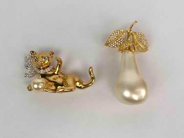 Lot of two signed Kenneth Jay Lane (KJL) brooches. The first features a playful gold tone cat with