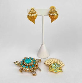 Lot of 2 brooches and a pair of clip on earrings by Kenneth Jay Lane. The first brooch is a turtle