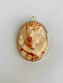 Detailed hand carved shell cameo depicting a classical female figure in profile, adorned with